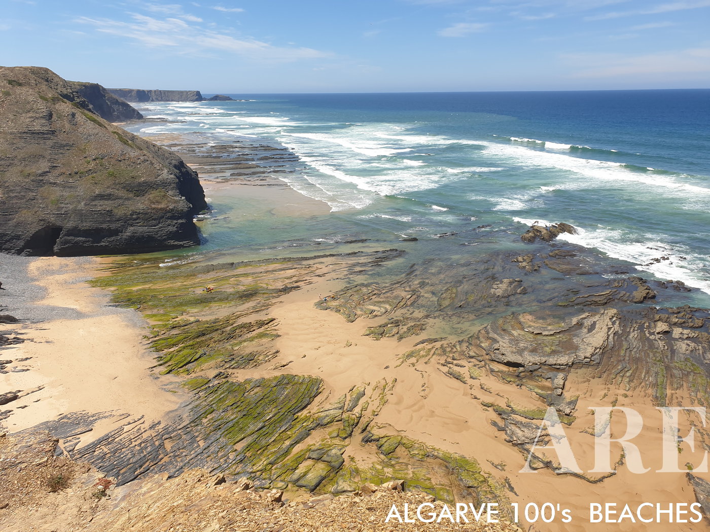 La vista sur de la playa de Monte Clérigo durante la marea baja revela un paisaje diverso. Las formaciones rocosas, intercaladas con arena suave, destacan las impresionantes vistas de los acantilados, presentando un retrato cautivador de esta zona costera.