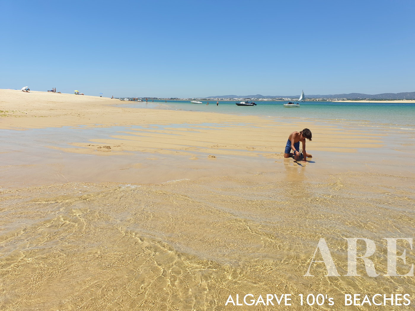 Punta de la isla de Culatra con marea baja, con la ciudad de Olhão al fondo