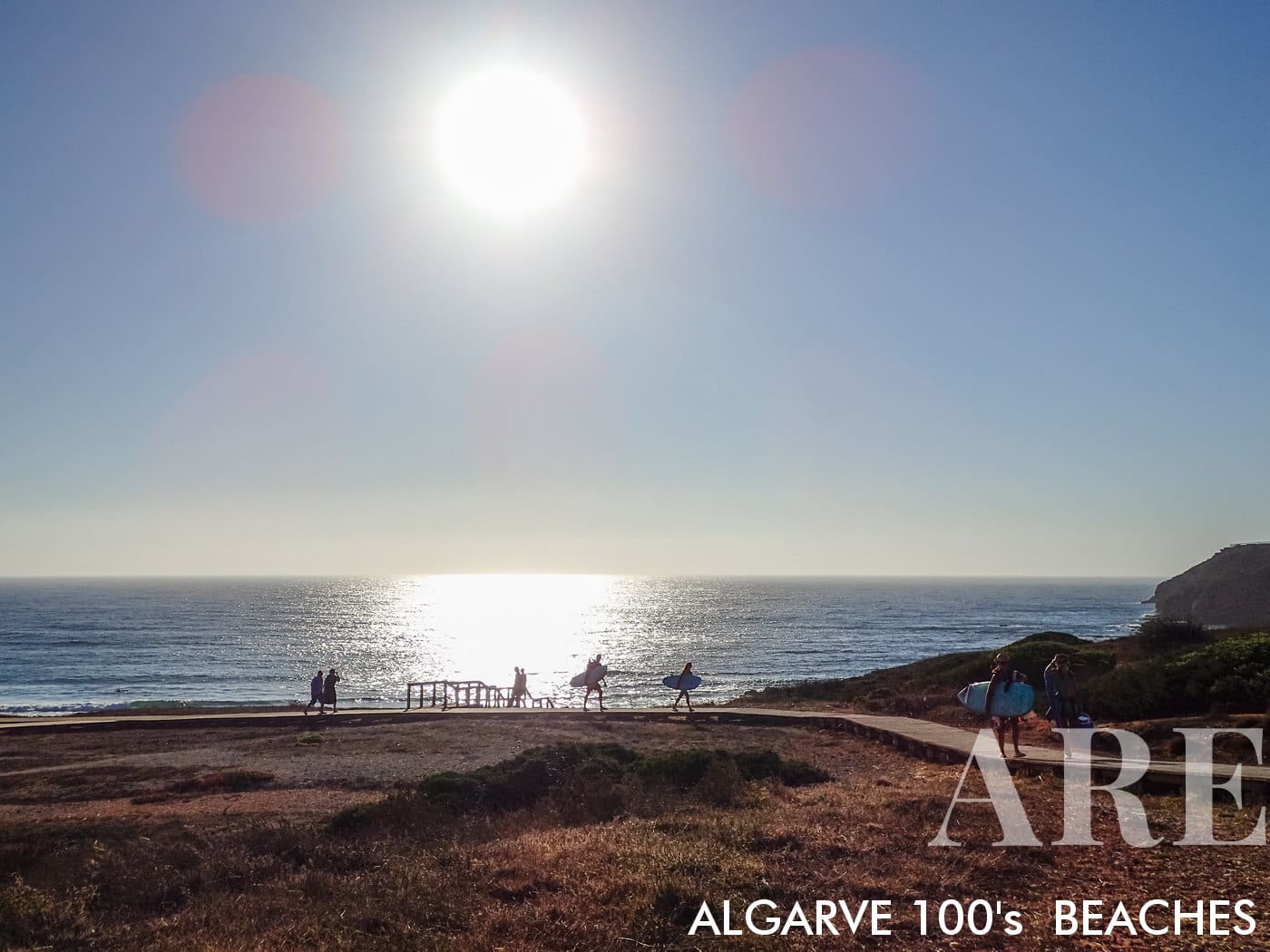 Las siluetas de los surfistas en la playa de Amado durante un atardecer de verano