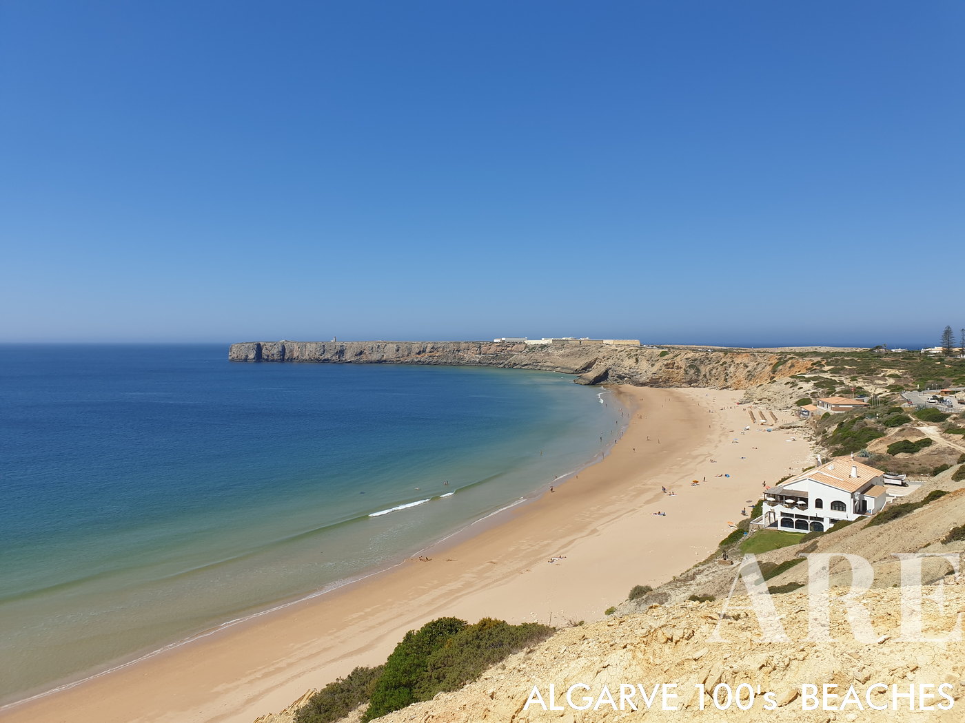 La playa de areta en Sagres, convenientemente accesible a pie desde el pueblo, presenta una vista impresionante de la imponente Fortaleza de Sagres que se alza orgullosa en primer plano.
