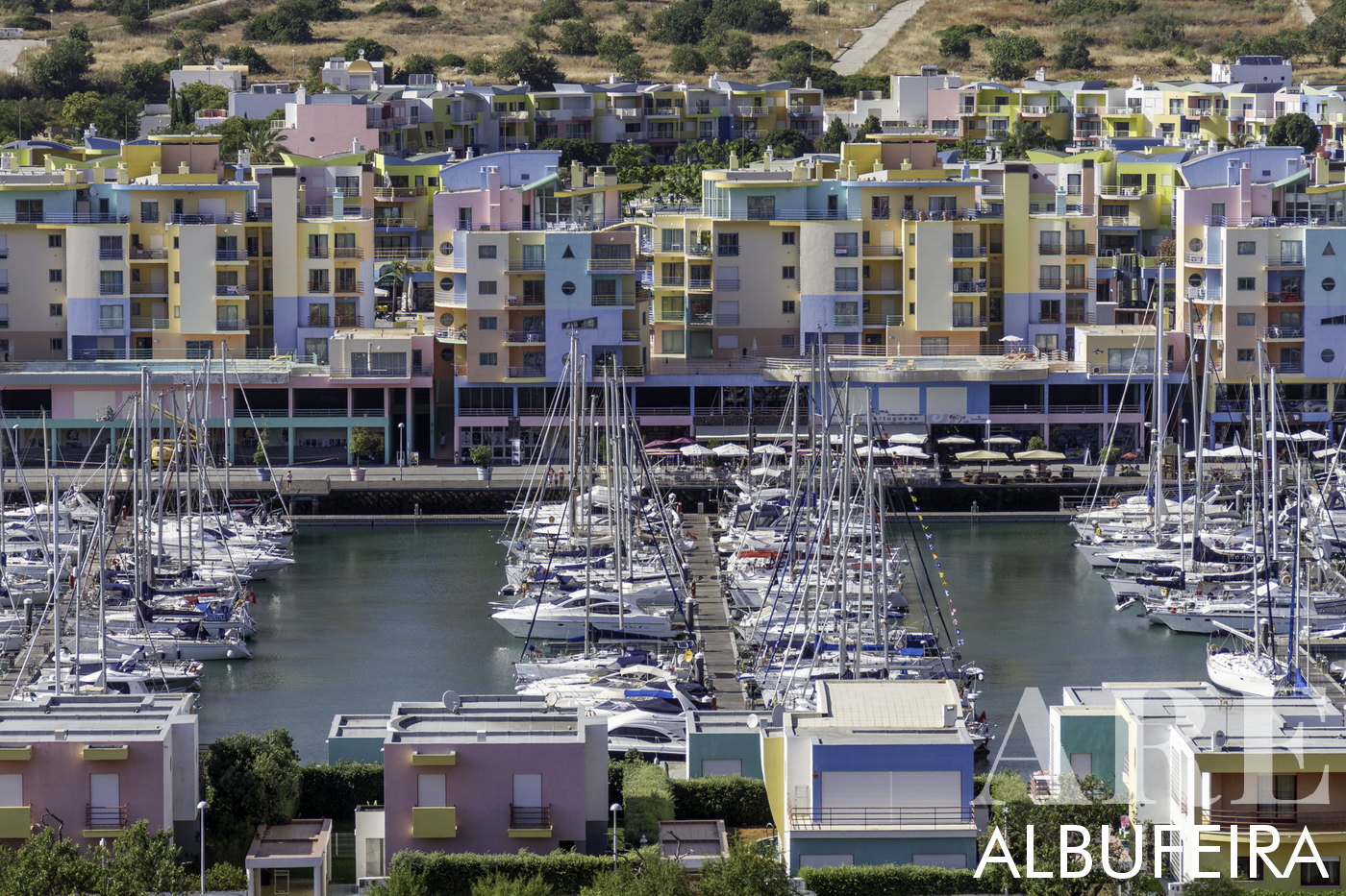 Marina d'Albufeira, avec ses bâtiments distinctifs jaunes, bleus, roses et oranges conçus par le célèbre architecte Taveira. Servant de point de départ pour les visites de la grotte de Benagil, l'observation des dauphins et la plongée, il abrite les célèbres excursions en bateau Zen Mar opérées par Marco et Anne. La marina est également agrémentée de restaurants, ce qui en fait un lieu privilégié de détente et de plaisirs culinaires.