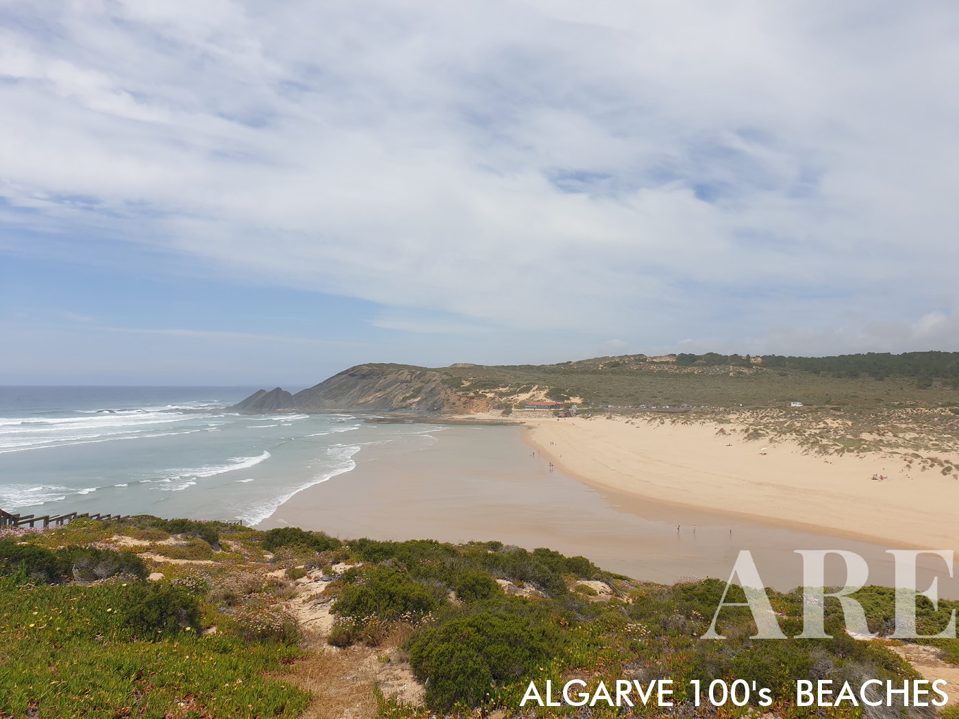 Desde lo alto del acantilado, la playa de Amoreira revela un impresionante paisaje de belleza natural. La vista está marcada por las dunas contra el fondo del océano.