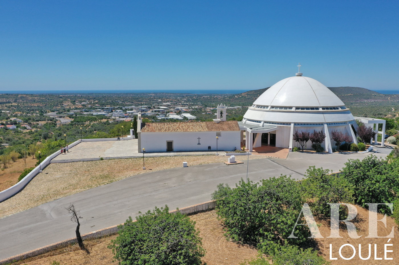 La vista aérea de Igreja da Nossa Senhora da Piedade en Loulé se extiende hacia la costa en un recorrido panorámico, ofreciendo una vista impresionante de aproximadamente 9 km de distancia en línea recta.