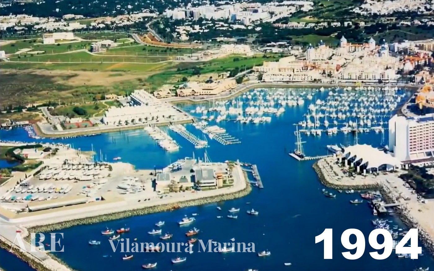 Vista aérea de 1994 da Marina de Vilamoura, apresentando um barco de pescador na entrada.