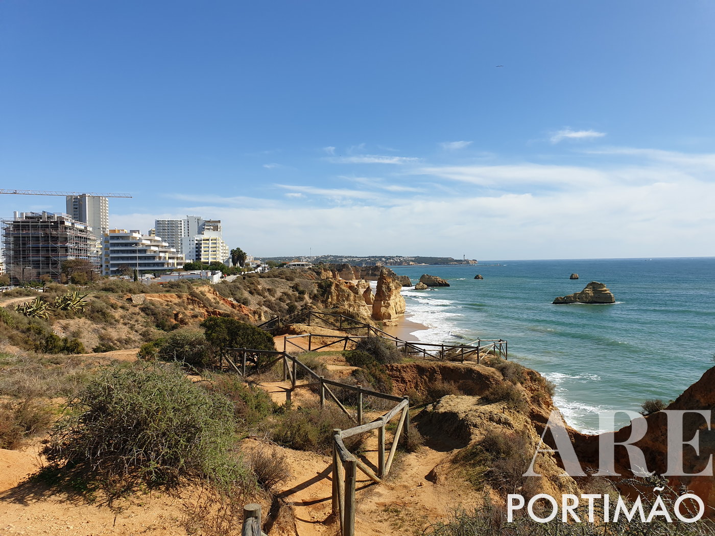 Portimão's Cliffside Apartments and Distant Lighthouse