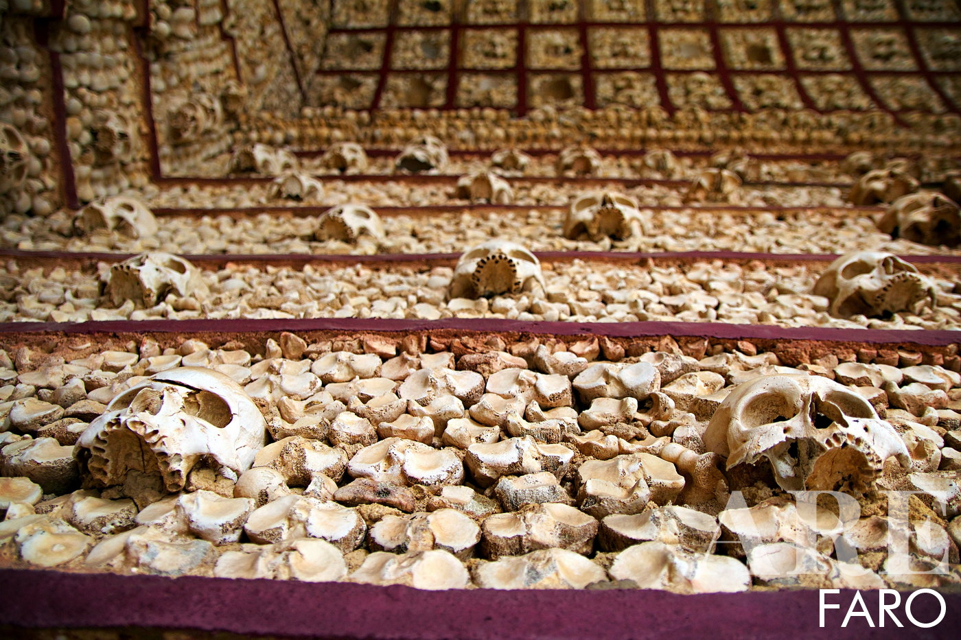 <strong>Chapel of Bones in Faro</strong> - is one of several bone chapels that exist in Portugal. The walls and ceiling are decorated with the bones and skulls of hundreds of monks. According to records, the purpose of this macabre decoration is to show the mortality and ephemerality of human life. When we enter, we can observe the bones arranged symmetrically and artistically, creating a strange and fascinating environment. Other bone chapels can be found throughout Europe, with the Chapel of Bones in Évora, Portugal being one of the most well-known. If you want to visit, the Chapel of Bones is located inside the Carmo Church in Faro, a beautiful baroque church.