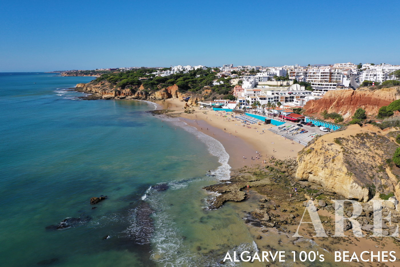Aerial perspective of Olhos d'Água, a traditional fisherman's beach. From this vantage point, the intricate tapestry of boats, nets and the azure waters unfold beneath you, offering a unique insight into a timeless lifestyle amidst breathtaking natural beauty.