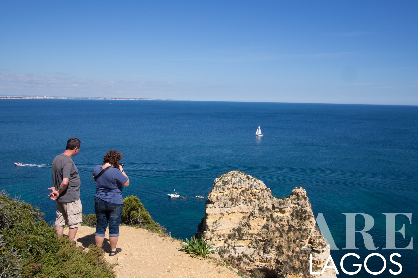 Turistas que captam a beleza das arribas costeiras de Lagos
